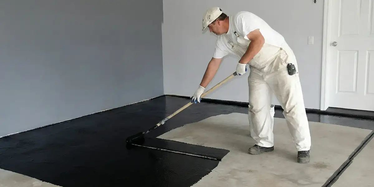 basement waterproofing professional applying waterproof coating to protect a basement floor in Jersey City, NJ